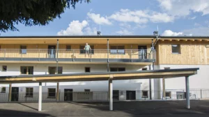 Person steht am Aufgang zu den einzelnen Wohnungen im Wohnpark Forstau