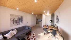 Innenansicht einer Wohnung im Projekt Piesendorf mit Holzsichtdecke und Sicht auf die Wohn- Essküche