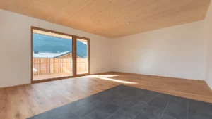 Wohnraum mit Sichtholzdecke und Holzbalkon