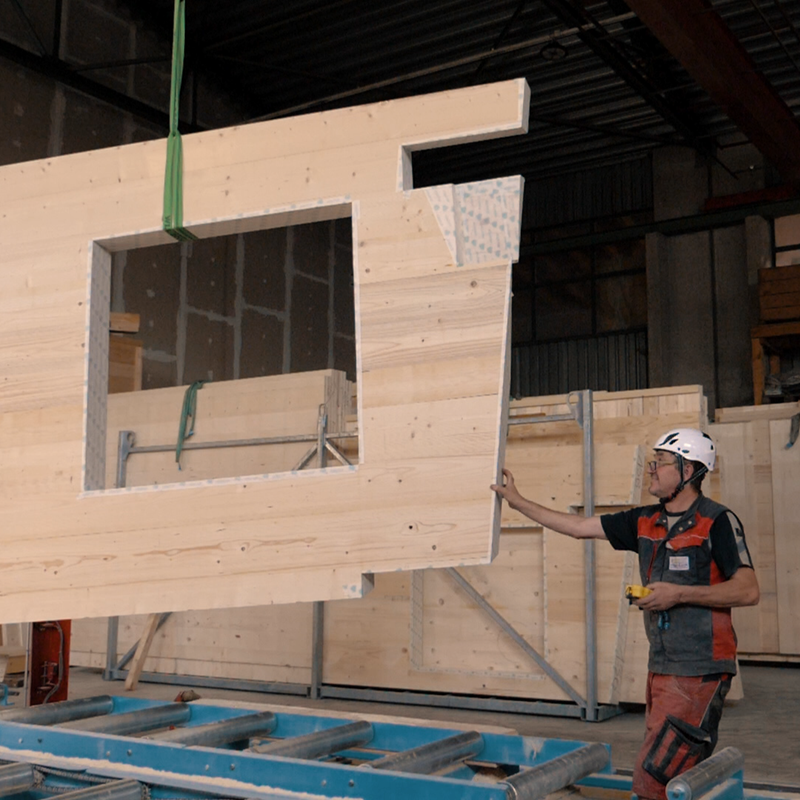 Produktionsmitarbeiter beim verheben einer Massivholzwand